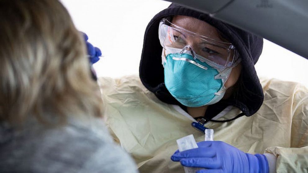 PHOTO: A medical assistant at St. Luke's Respiratory Clinic in Duluth, Minnesota administers a COVID-19 test to a patient in their drive-through testing site, Nov. 3, 2020.