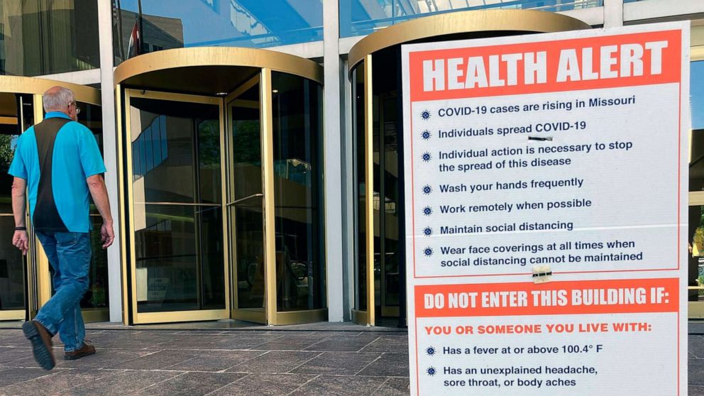 PHOTO: A sign warning of COVID-19 dangers remains in place on June 15, 2021, outside the entryway of a state office building in Jefferson City, Mo.