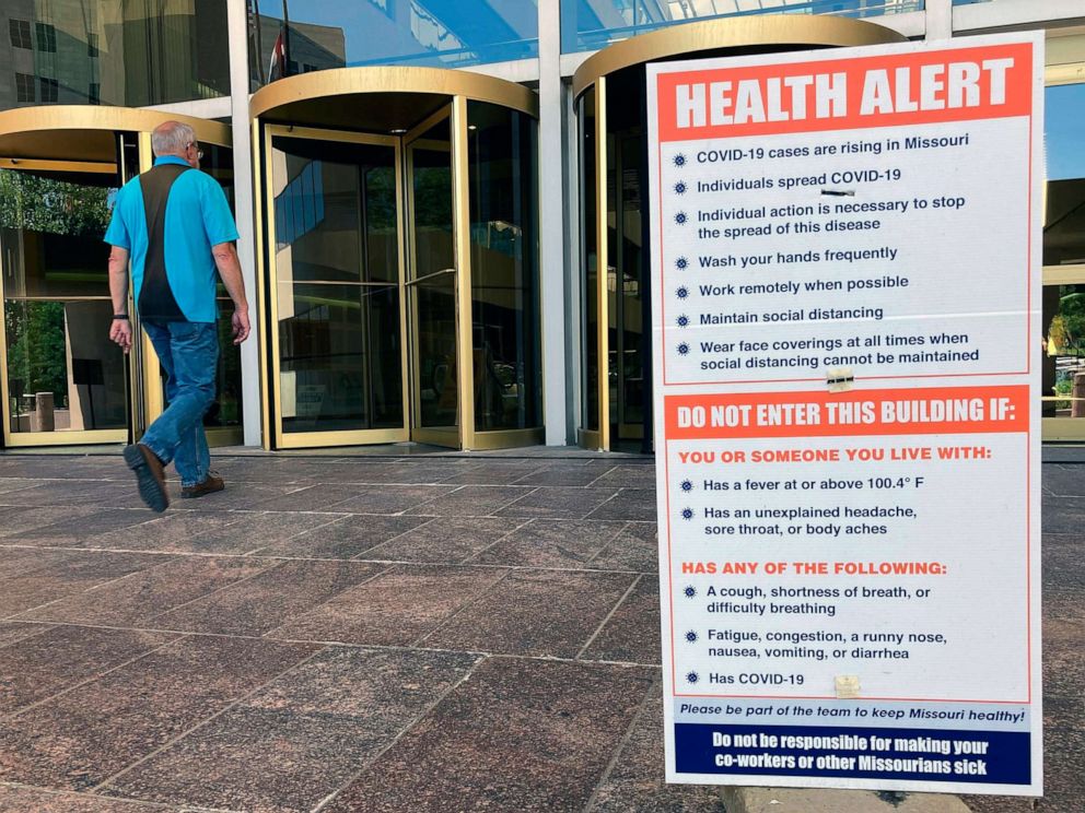PHOTO: A sign warning of COVID-19 dangers remains in place on June 15, 2021, outside the entryway of a state office building in Jefferson City, Mo.