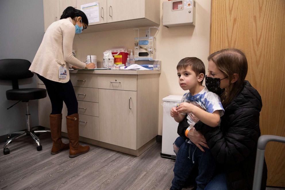 PHOTO: Ilana Diener holds her son, Hudson, 3, during an appointment for a Moderna COVID-19 vaccine trial in Commack, N.Y., Nov. 30, 2021. 