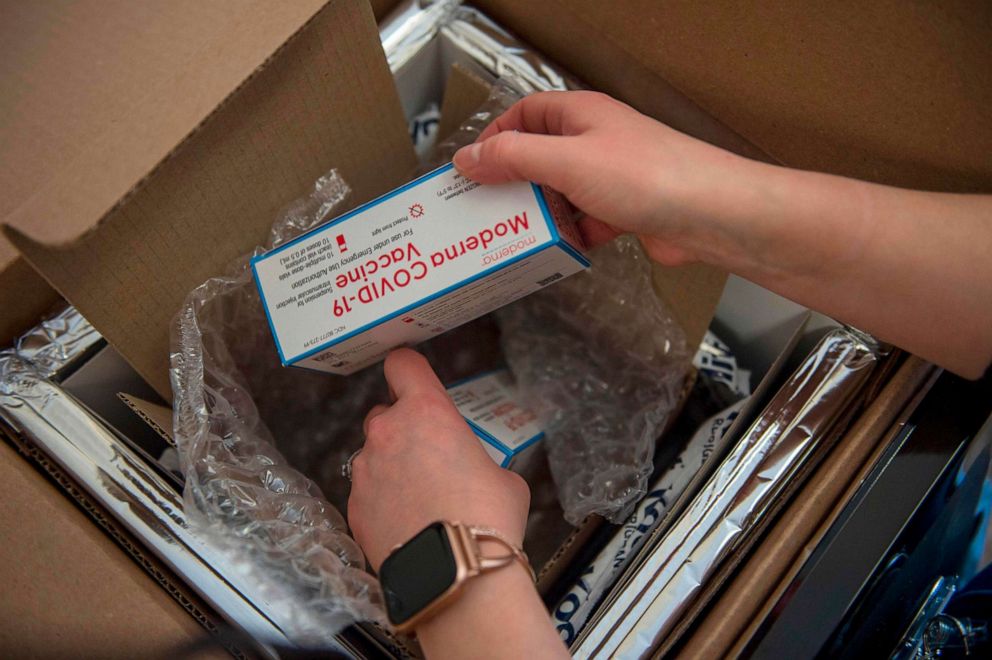 PHOTO: Nurse Courtney Senechal unpacks a special refrigerated box of Moderna COVID-19 vaccines as she prepared to ready more supply for use at the East Boston Neighborhood Health Center in Boston on Dec. 24, 2020. 