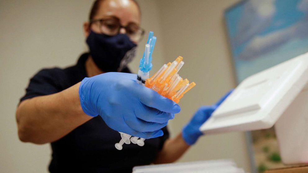 PHOTO: A healthcare worker holds syringes with the Moderna and Pfizer vaccines against COVID-19 at a vaccination centre, in El Paso, Texas, May 6, 2021.