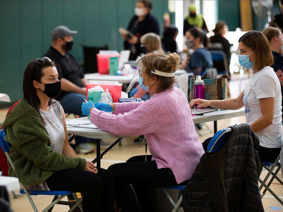 PHOTO: Registered nurse Angela Biccolo administers a dose of the Moderna COVID-19 vaccine to a Revere school teacher during a vaccine clinic for teachers and school administrators at the Rumney March Academy, in Revere, Mass., March 12, 2021. 