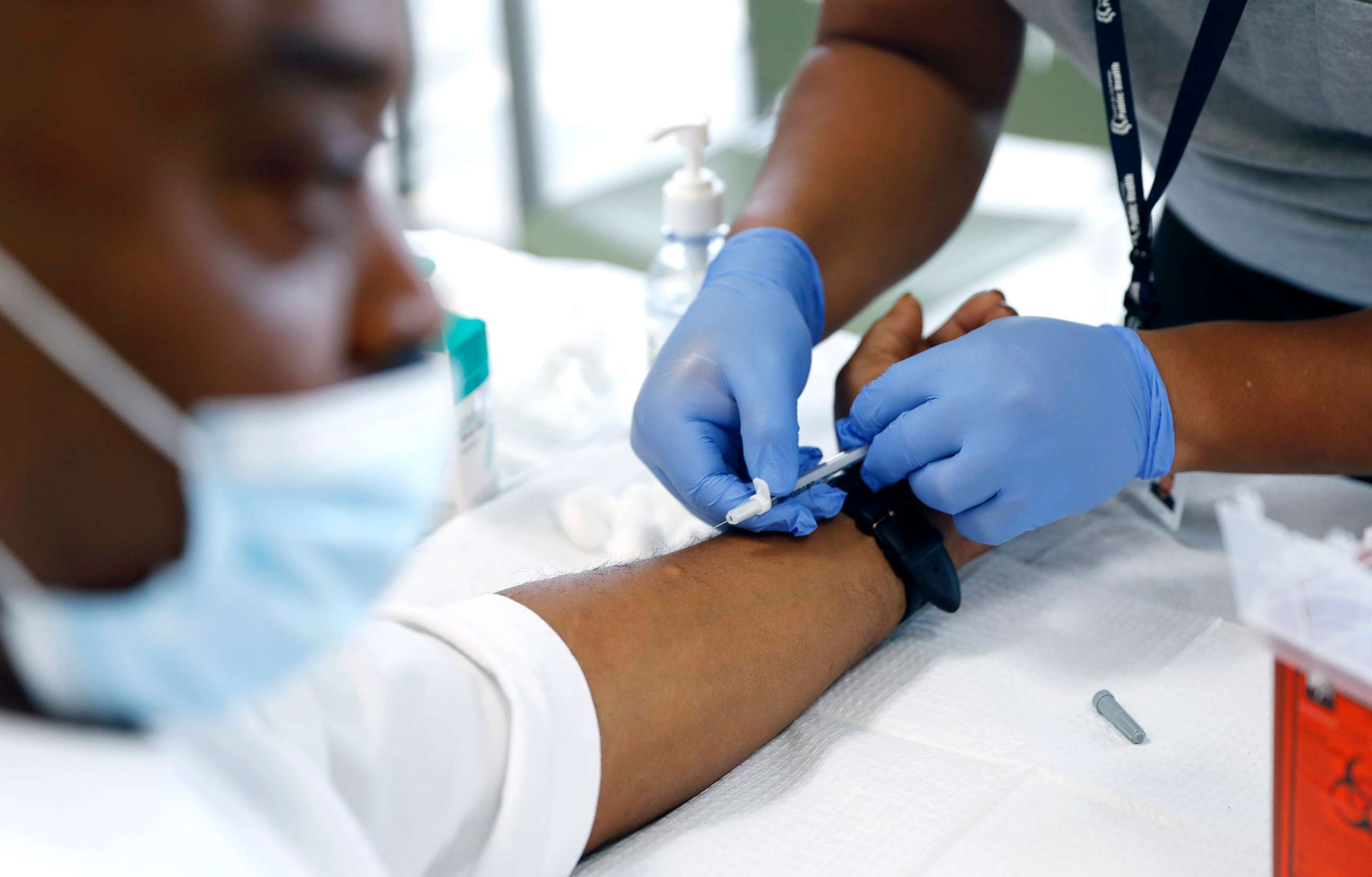 PHOTO: David Hightower, 57, left, looks away while receiving the monkeypox vaccine by registered nurse Jeremy Oyague, right, at a vaccination clinic at The Village Mental Health Services in Los Angeles, Aug. 23, 2022.