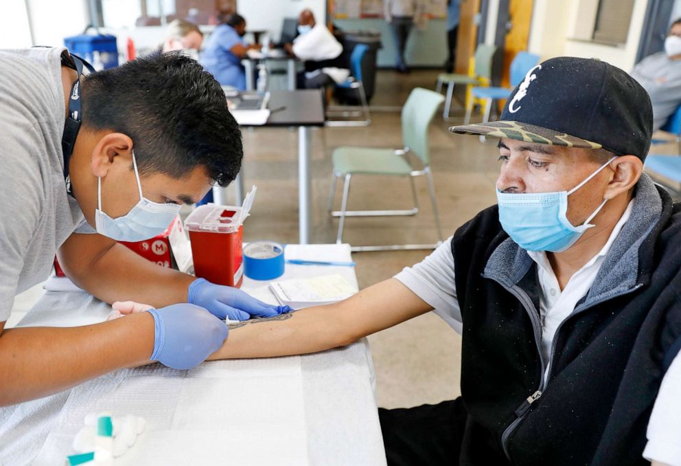 PHOTO: Jeremy Oyague, right, a registered nurse with The Los Angeles Department of Public Health, left, administers a monkeypox vaccine to Victor Zepeda, 44, at a vaccination clinic at The Village Mental Health Services in Los Angeles, Aug. 23, 2022. 