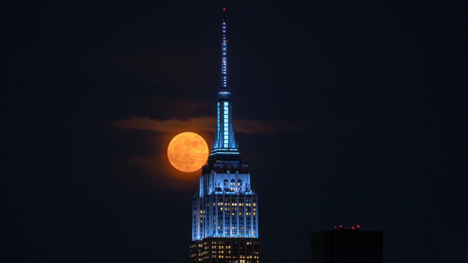 PHOTO: The Strawberry Moon rises behind the skyline of midtown Manhattan and the Empire State Building in New York City, June 10, 2025.