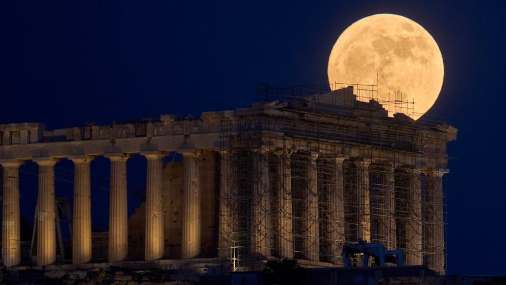 PHOTO: The Strawberry Moon rises in the sky behind the 5th century B.C. Parthenon temple at the ancient Acropolis hill, in Athens, June 10, 2025. 