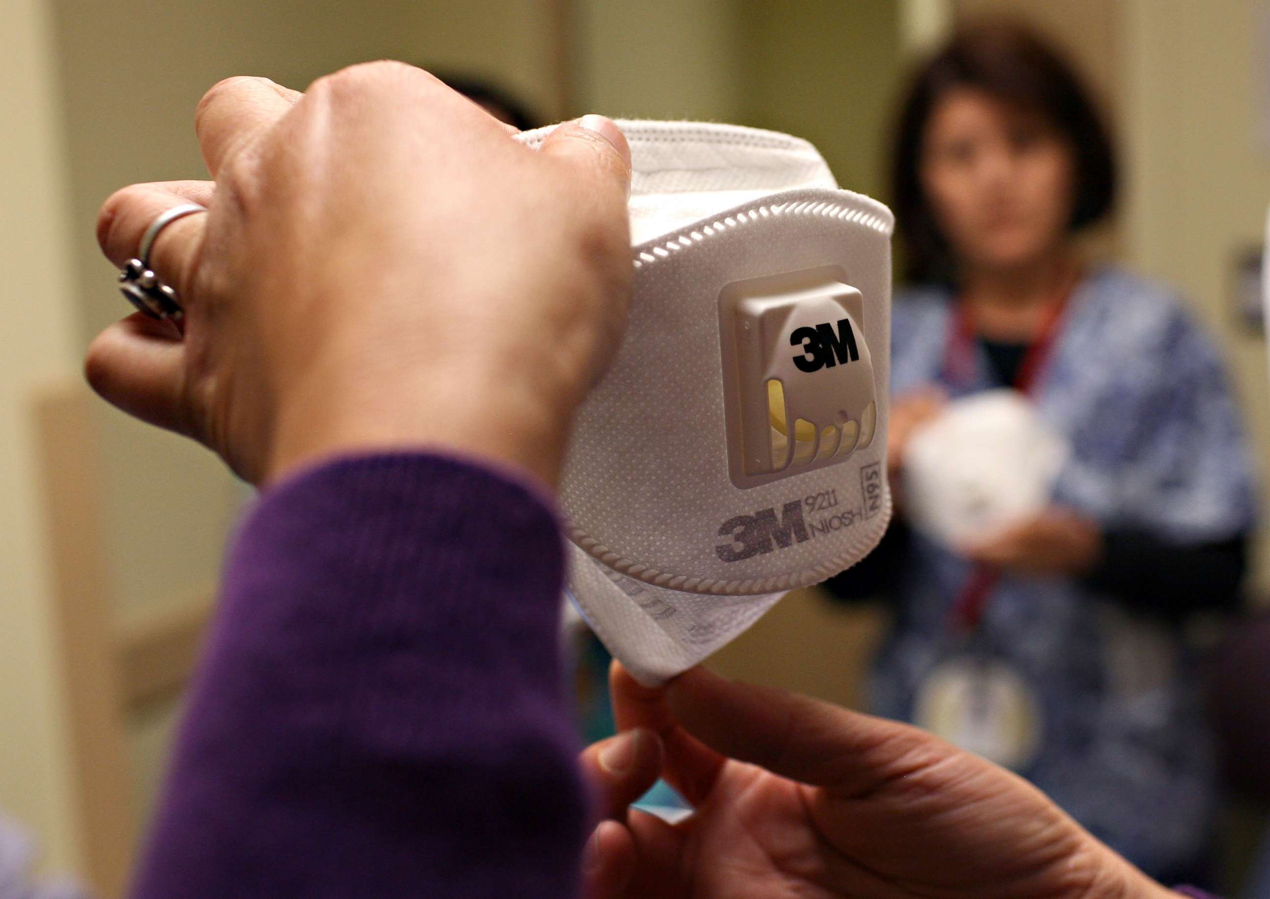 PHOTO: A woman demonstrates how to use the N95 respiratory mask, April 28, 2009, in Oakland, Calif.