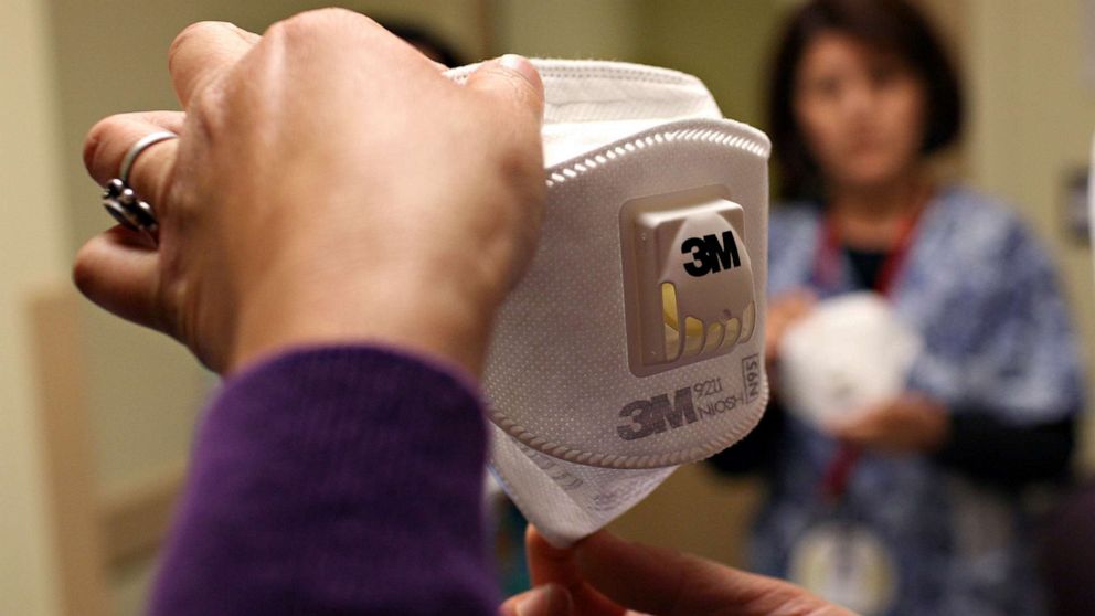 PHOTO: A woman demonstrates how to use the N95 respiratory mask, April 28, 2009, in Oakland, Calif.