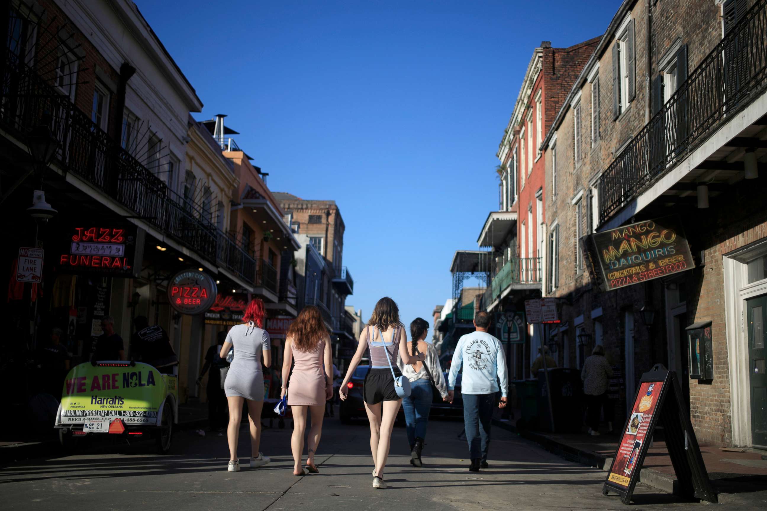 PHOTO: Pedestrians walk along Bourbon Street in New Orleans, Louisiana, April 20, 2021.