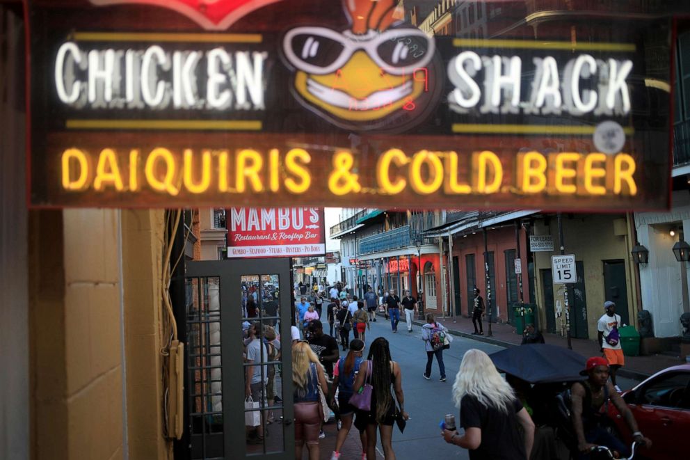 PHOTO: Pedestrians walk along Bourbon Street in New Orleans, Louisiana, April 20, 2021.