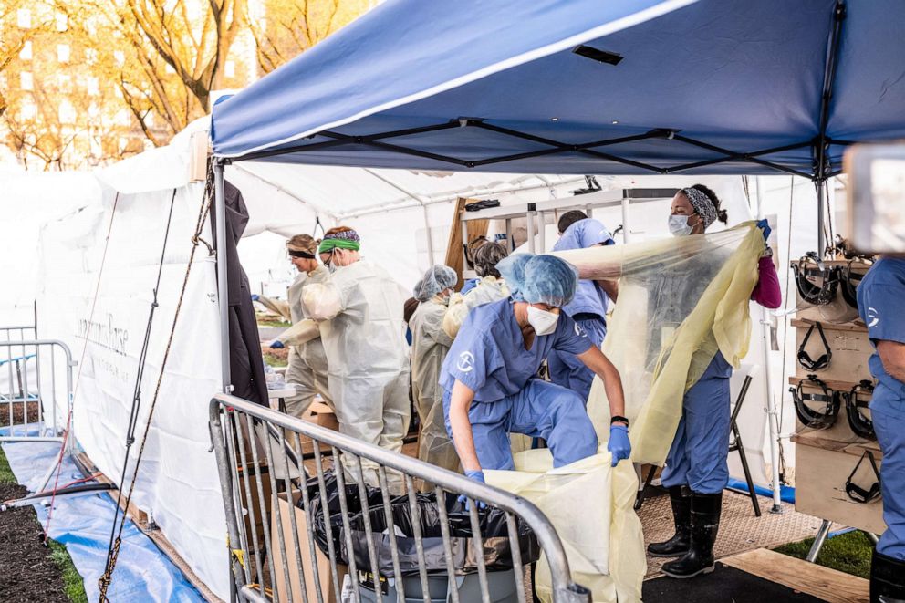 PHOTO: Medical workers putting on PPEs at the beginning of their shift at the emergency field hospital run by Samaritan's Purse and Mount Sinai Health System in Central Park on April 08, 2020, in New York.