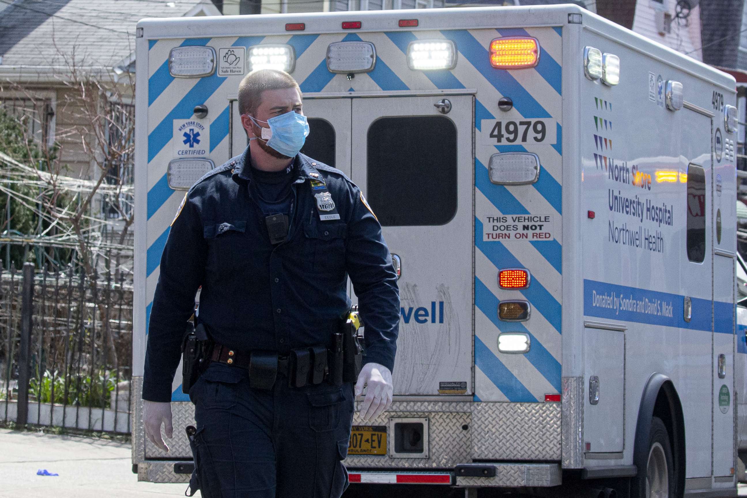 PHOTO: An NYPD Officers helps remove a patient from a house on April 7, 2020, in Queens, New York.