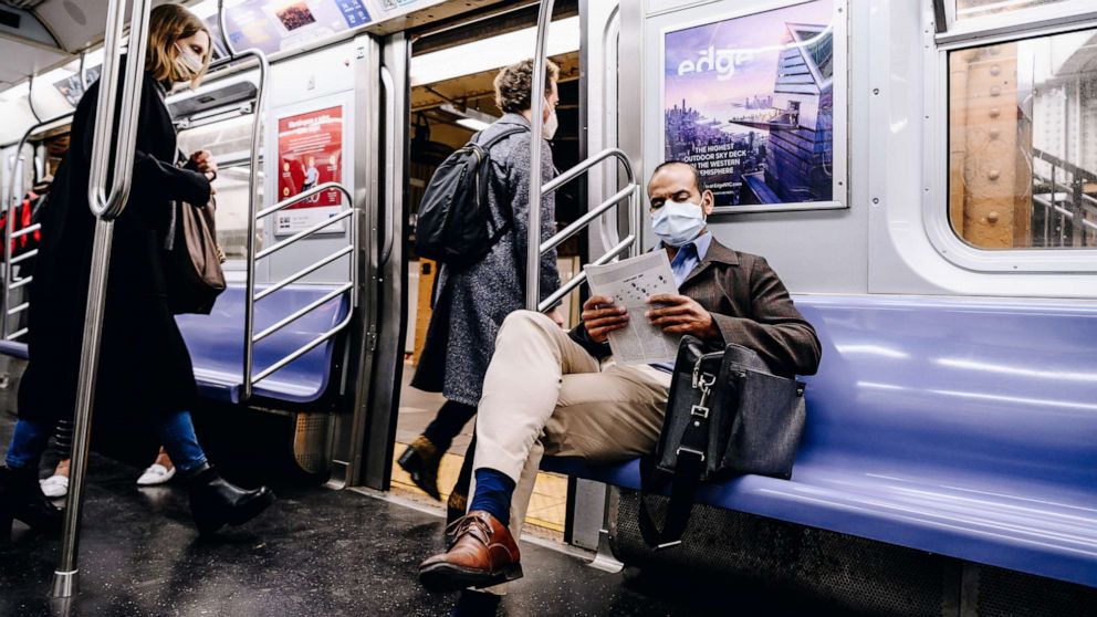 PHOTO: A passenger wearing a protective mask reads while riding on the L subway train in New York, April 13, 2021.