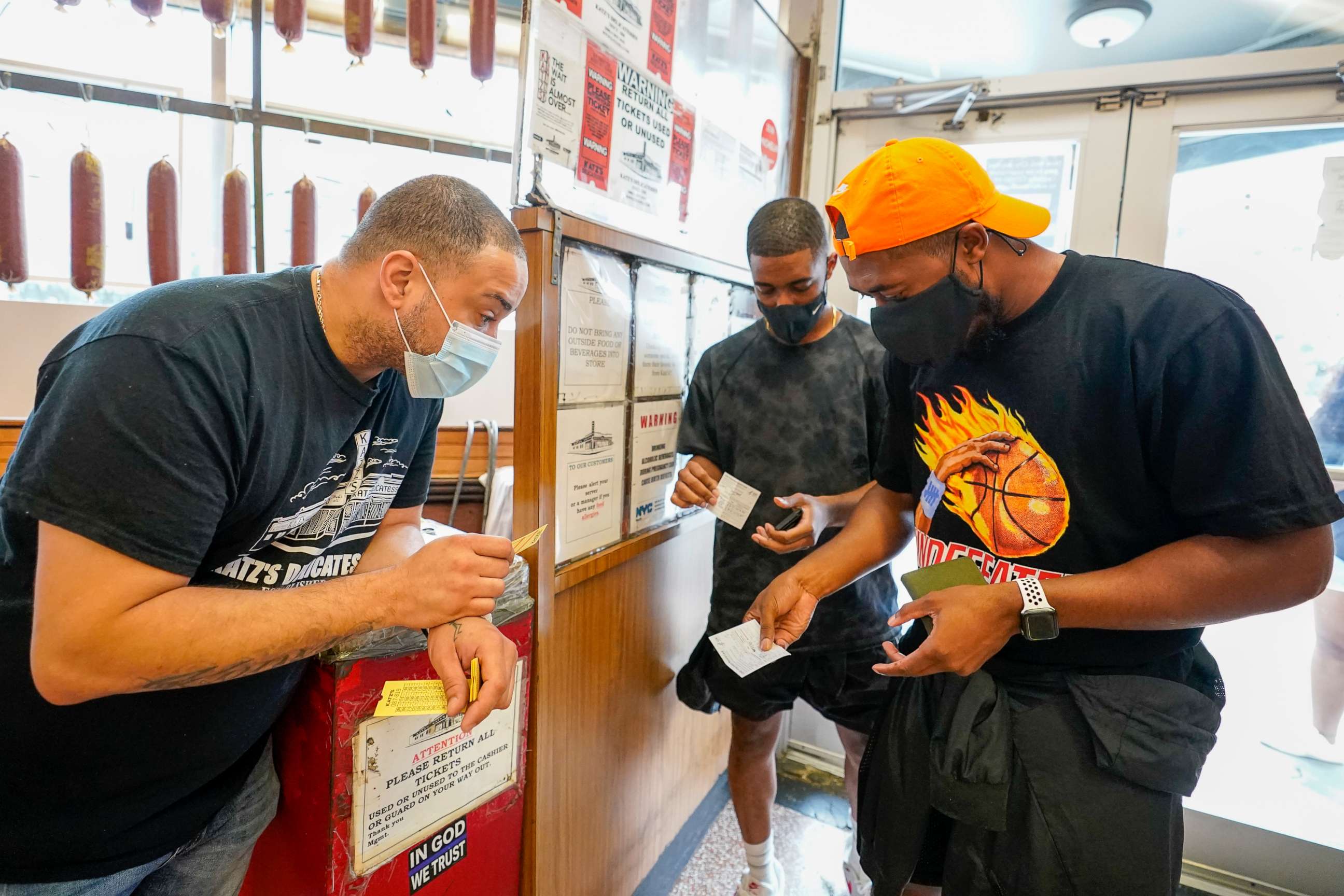 PHOTO: A Katz's Deli employee checks the proof of vaccination from customers who want to eat inside the restaurant, Aug. 17, 2021, in New York.