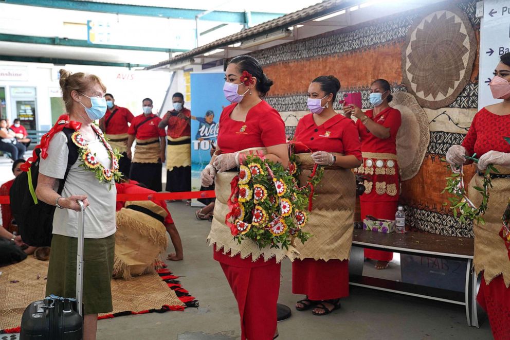 PHOTO: An international visitor is welcomed with a kahoa (garlands) by Tonga Ministry of Tourism staff upon arriving in Tonga from Auckland, New Zealand, on the first flight under the new open border policy at Fua'amotu International Airport, Aug. 1, 2022