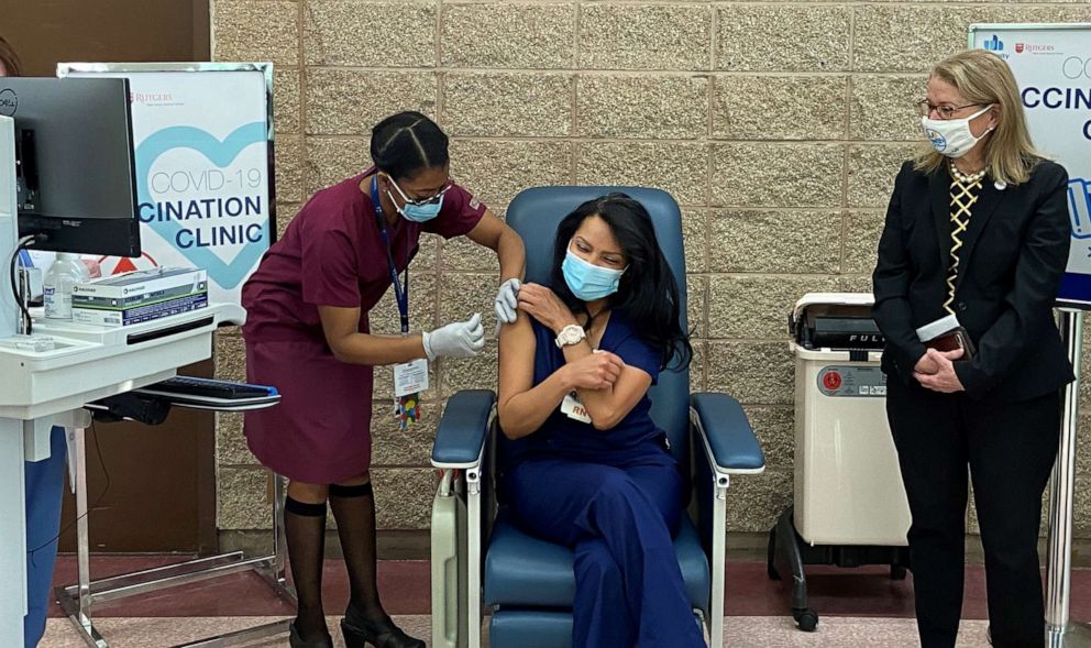 PHOTO: Nurse Martiza Beniquez, center, receives the first COVID vaccine shot in New Jersey at University Hospital in Newark as state Health Commissioner Judy Persichilli, right, looks on, Dec. 15, 2020.