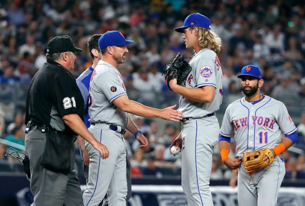 PHOTO: New York Mets manager Mickey Callaway, second from left, talks to starting pitcher Noah Syndergaard during the sixth inning of the team's baseball game against the New York Yankees, July 20, 2018, in New York.