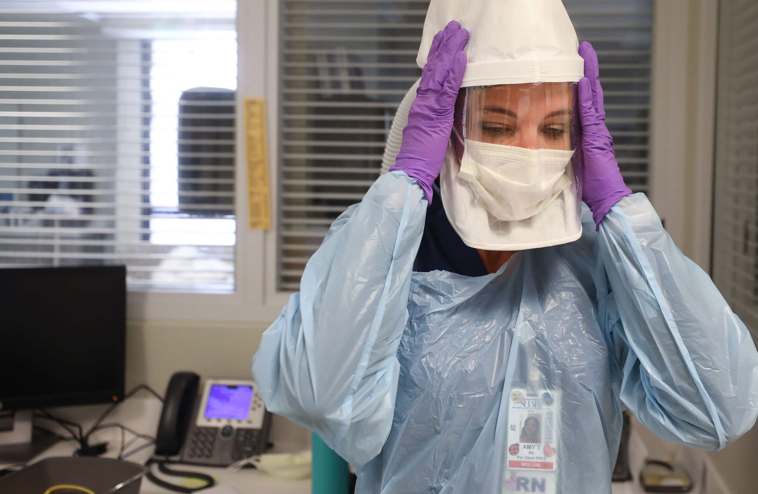 PHOTO: Nurse Amy Tyson adjusts her personal protective equipment before caring for a COVID-19 patient in the Intensive Care Unit at Sharp Memorial Hospital amidst the coronavirus pandemic on May 6, 2020, in San Diego.