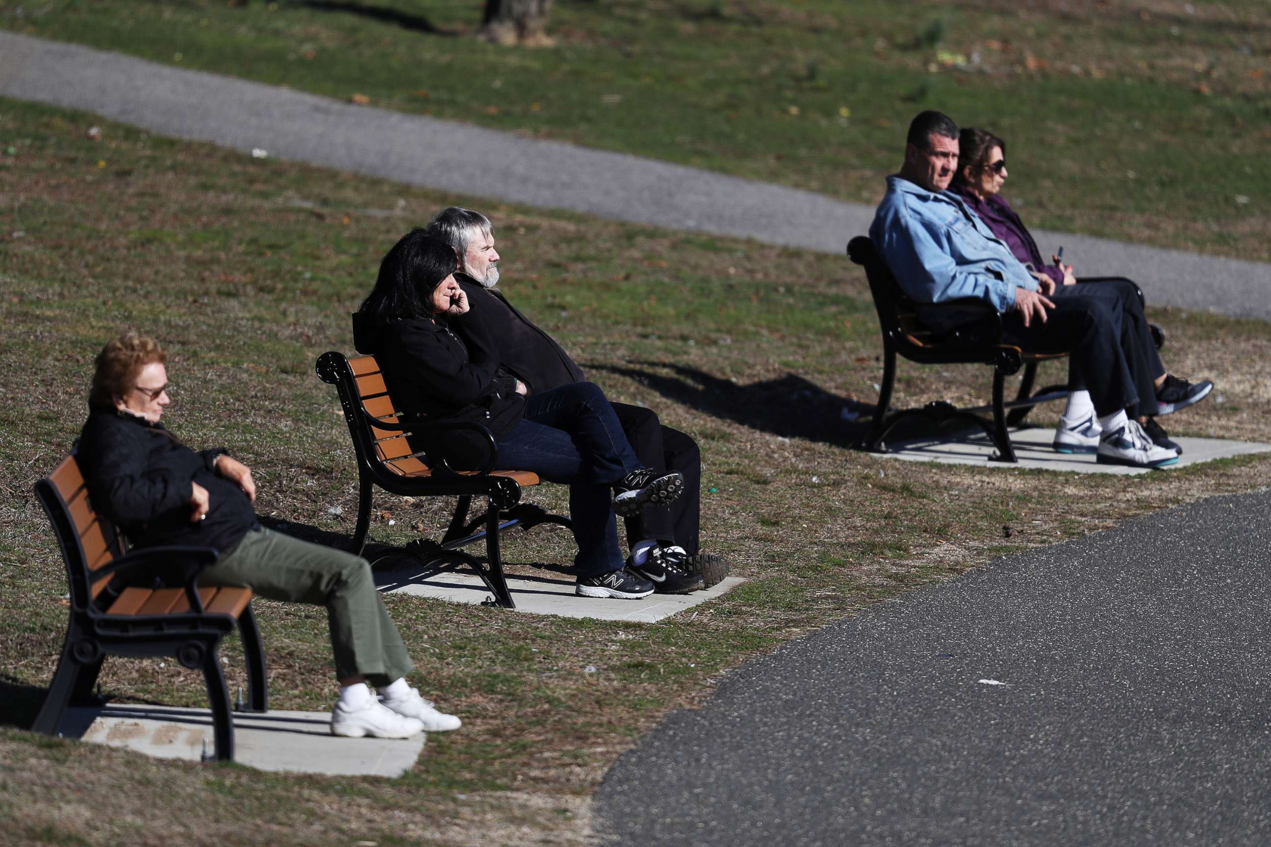 PHOTO: People sit on a park bench at Eisenhower Park, on March 21, 2020, in East Meadow, New York. Authorities have encouraged people keep a social distance of six feet or more to curtail the spread of the coronavirus.