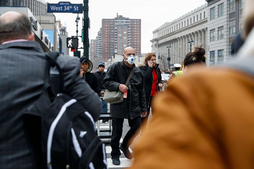 PHOTO: A pedestrian wears a face mask during the coronavirus outbreak while crossing West 34th Street in New York City, March 12, 2020.