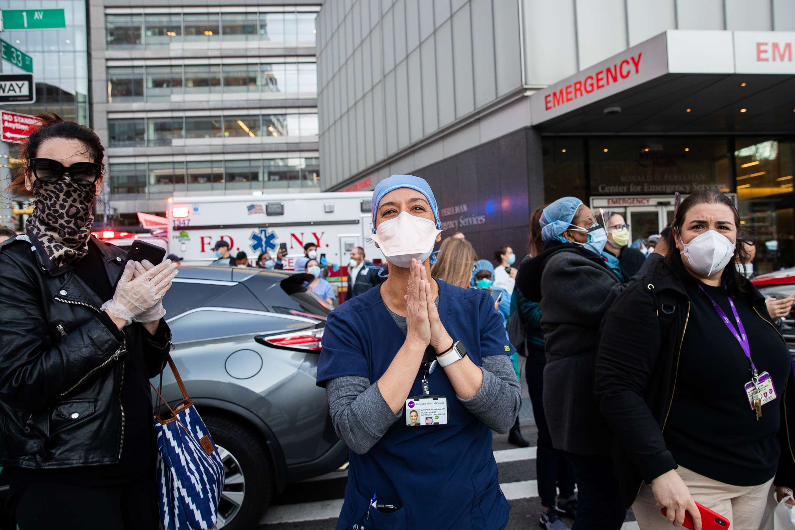 PHOTO: Medical workers stand outside NYU Langone Health hospital as people applaud to show their appreciation to medical staff and essential workers on the front lines of the coronavirus pandemic, April 21, 2020 in New York.
