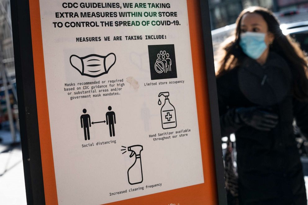 PHOTO: Pedestrians wearing protective masks walk along Broadway in the SoHo district of New York, Friday, March 4, 2022. Mayor Eric Adams announced in a morning news conference that the city will be scaling back of COVID-19 mask and vaccine mandates