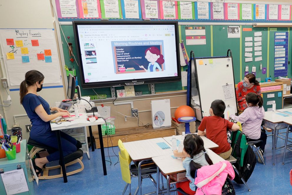 PHOTO: Co-teachers at Yung Wing School P.S. 124 Marisa Wiezel, left, and Caitlin Kenny give a lesson to their masked students in their classroom on Sept. 27, 2021, in New York City.