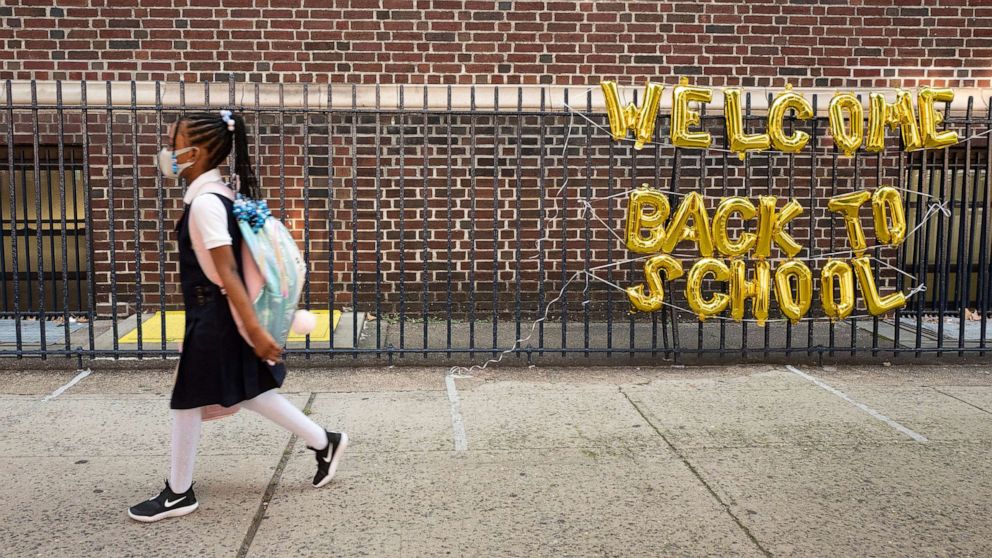 PHOTO: A girl passes a "Welcome Back to School" sign as she arrives for the first day of class at Brooklyn's PS 245 elementary school, Sept. 13, 2021, in New York.
