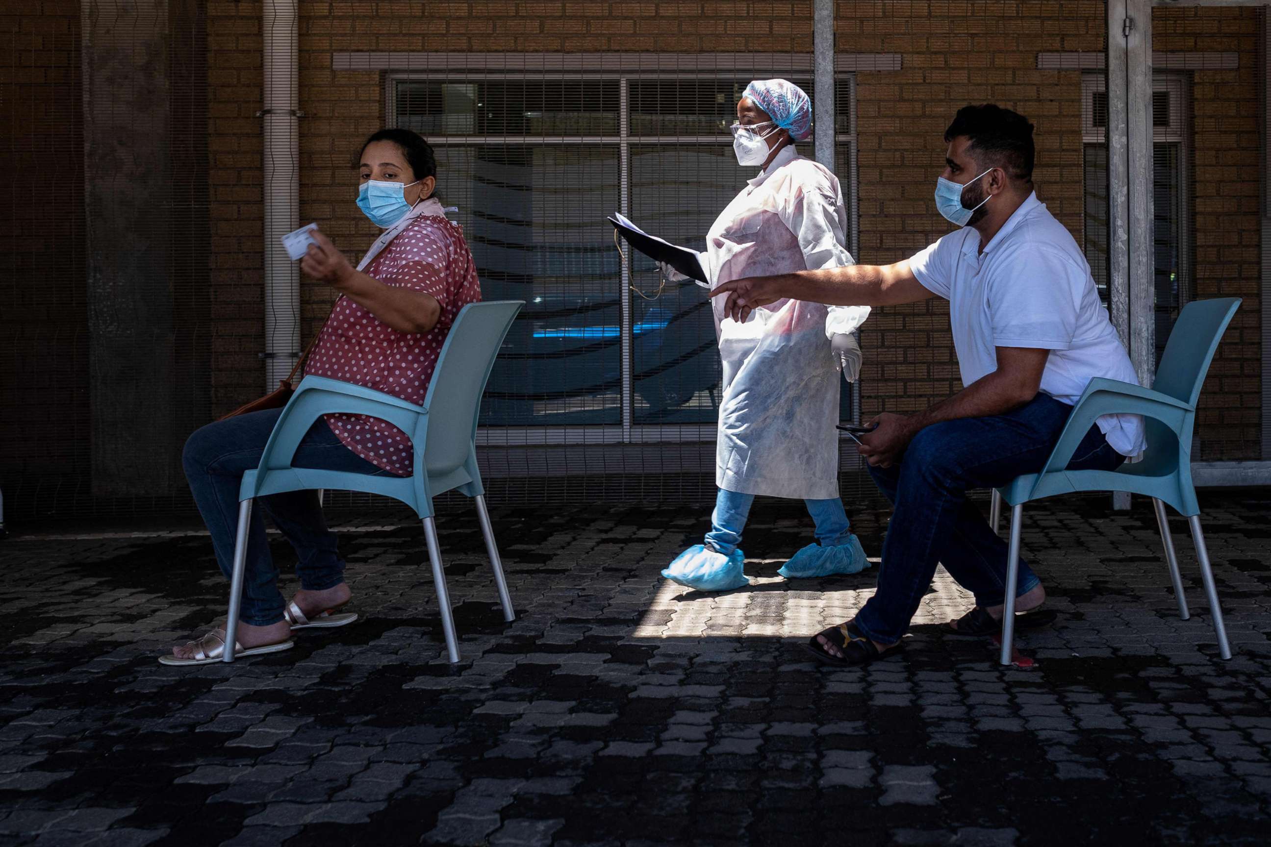 PHOTO: People queue for a PCR COVID-19 test at the Lancet laboratory in Johannesburg, South Africa, Nov. 30, 2021. 