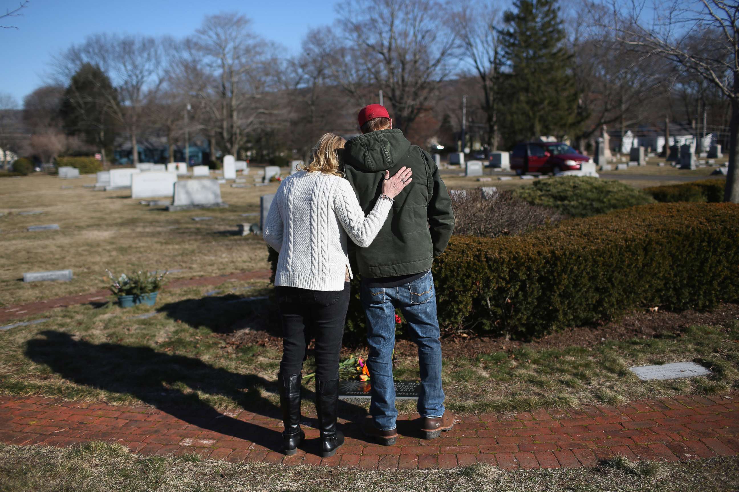 PHOTO: Family members embrace in a cemetery near the grave of a loved one who died of a heroin overdose.