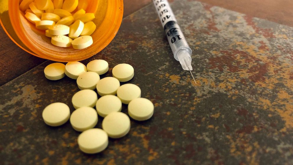 PHOTO: Opioid pills sit next to a syringe in an undated stock image.