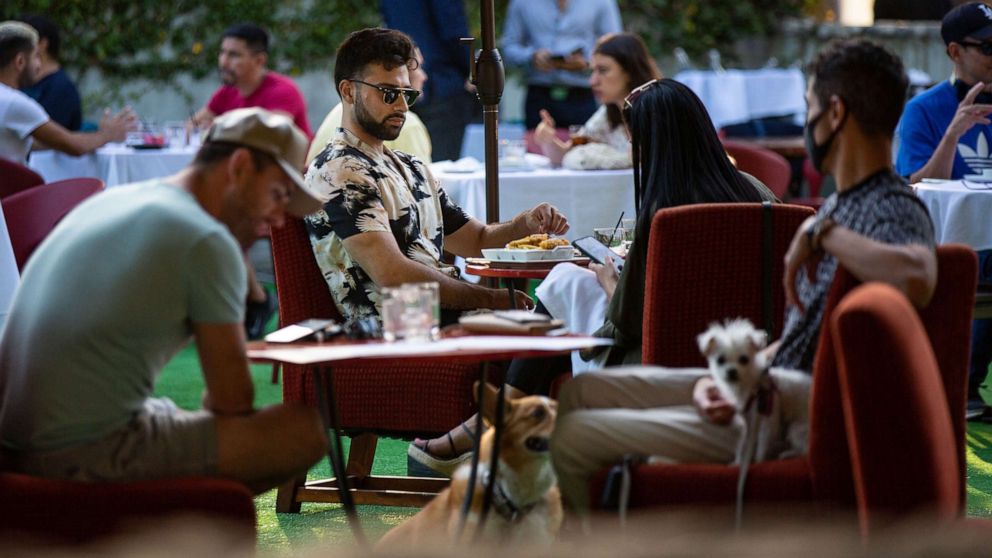 PHOTO: People have drinks and dine on the outdoor patio at La Boheme in West Hollywood as coronavirus surges on July 8, 2020, in Los Angeles, Calif.