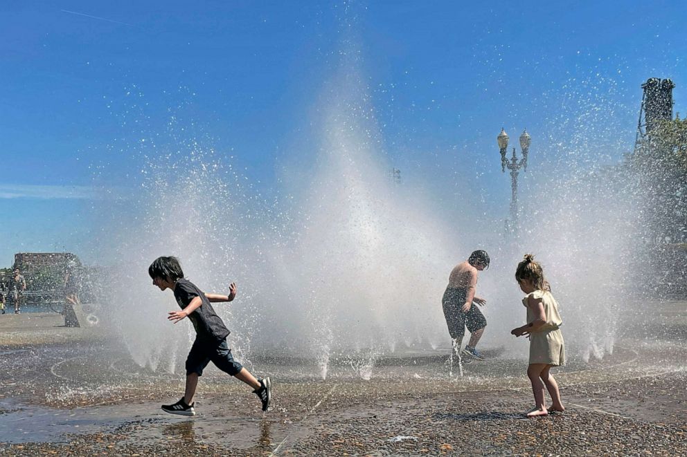 PHOTO: Children play in a fountain to cool off in downtown Portland, Ore., May 12, 2023.