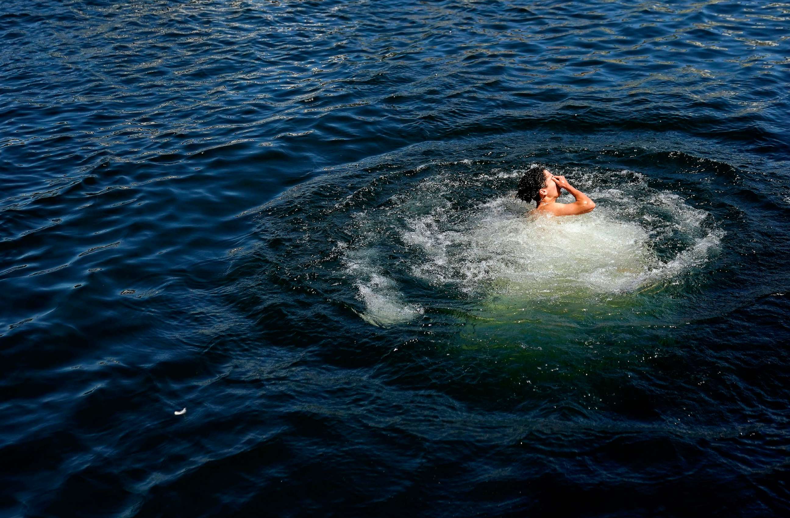 PHOTO: A diver wipes water from their face after jumping off a footbridge at Lake Union Park, May 13, 2023, in Seattle.