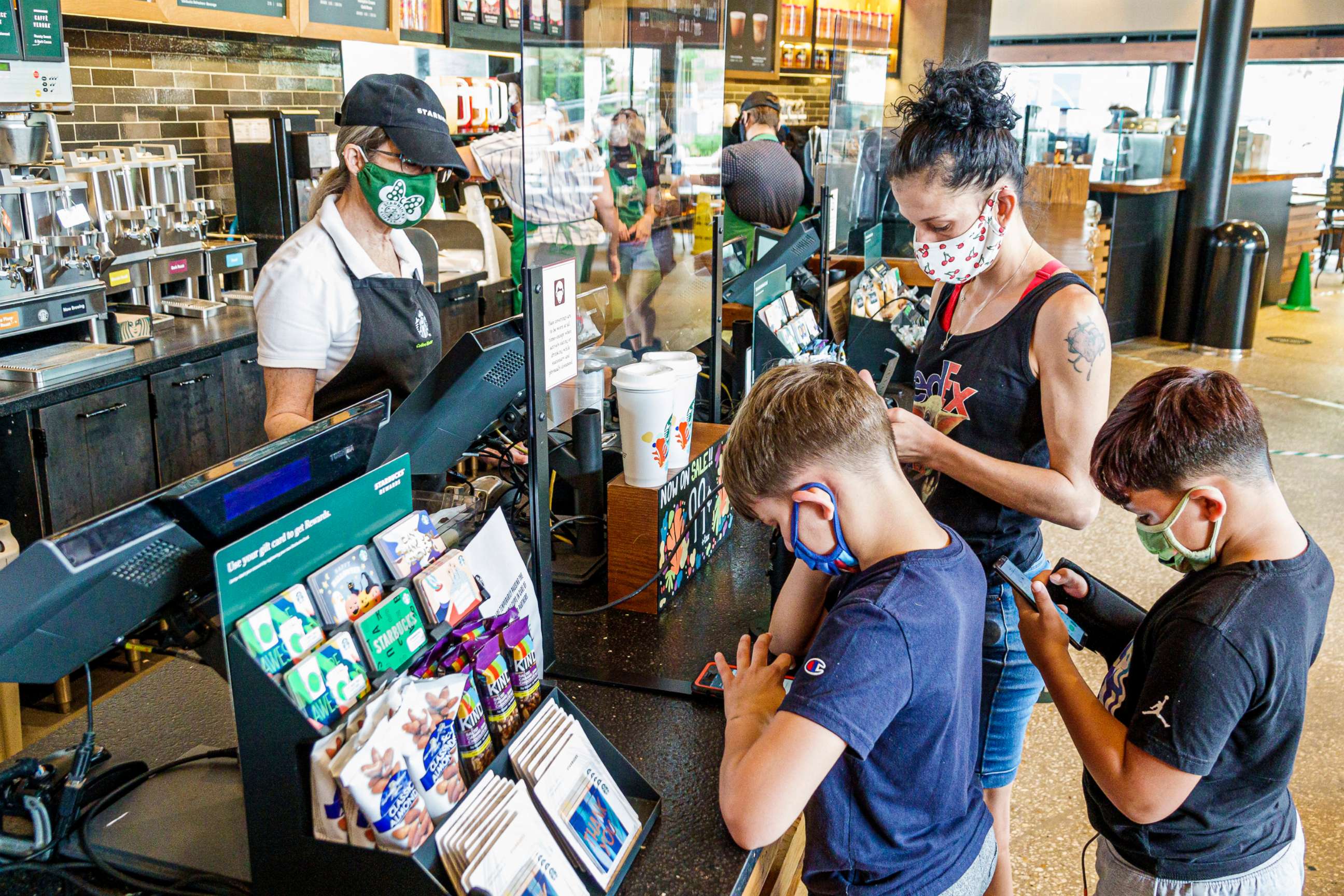 PHOTO: A mother and her sons all wear face masks while they shop at a Starbucks coffee shop in Orlando, Fla., Sept. 27, 2020. 