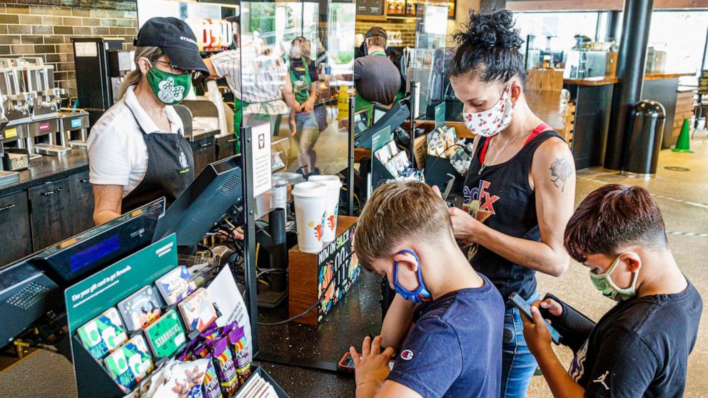 PHOTO: A mother and her sons all wear face masks while they shop at a Starbucks coffee shop in Orlando, Fla., Sept. 27, 2020. 