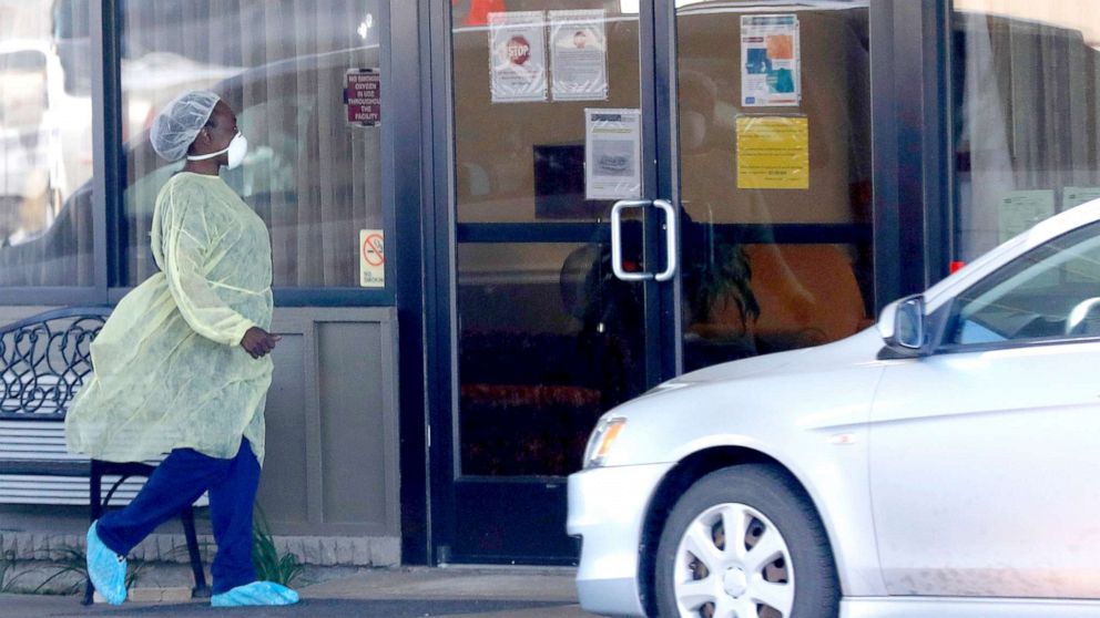 PHOTO: A medical worker wearing personal protective equipment walks outside the Paris Healthcare Center in Paris, Texas, April 29, 2020.