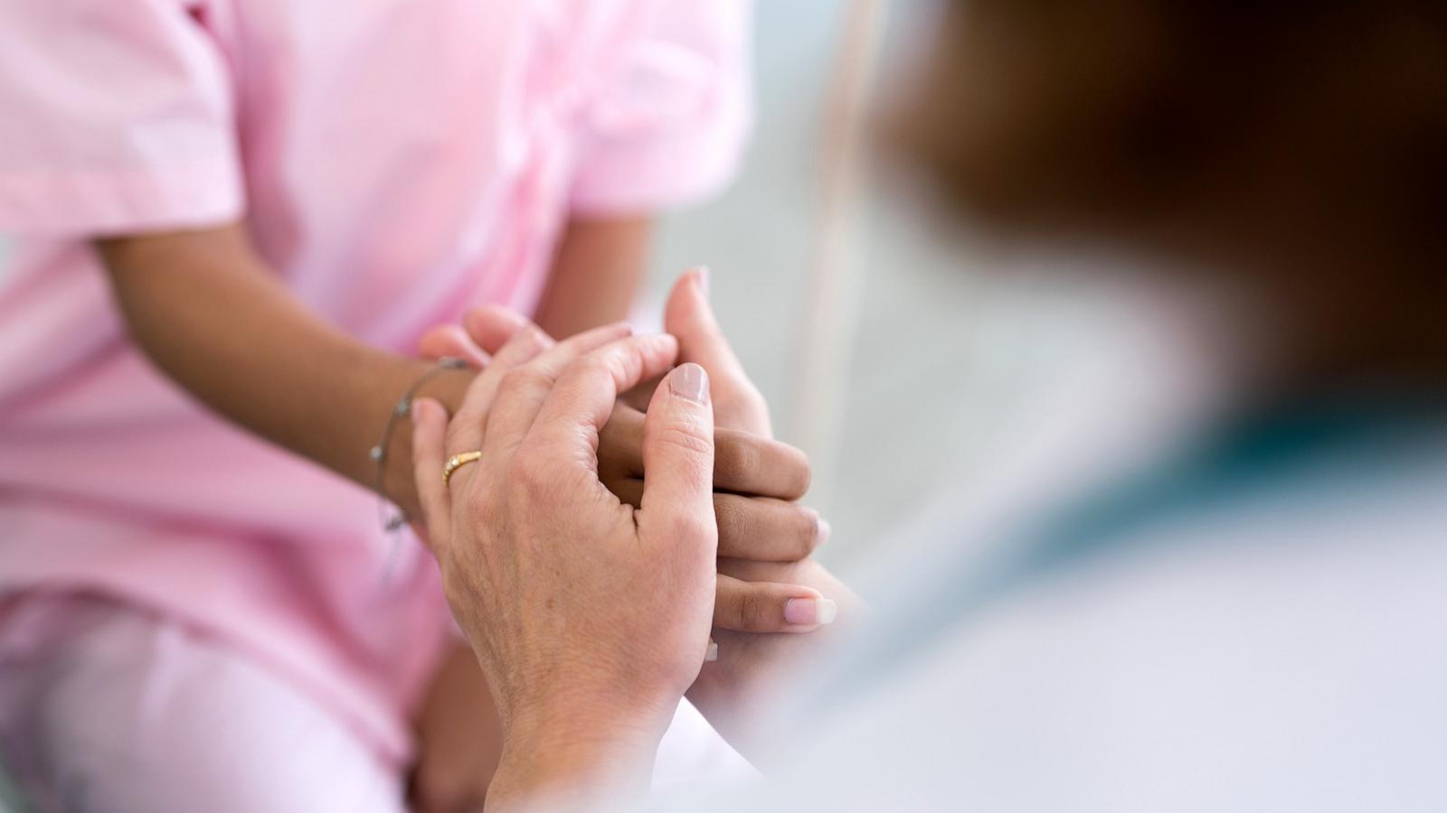 PHOTO: Stock photo of a doctor holding the hands of a young patient.