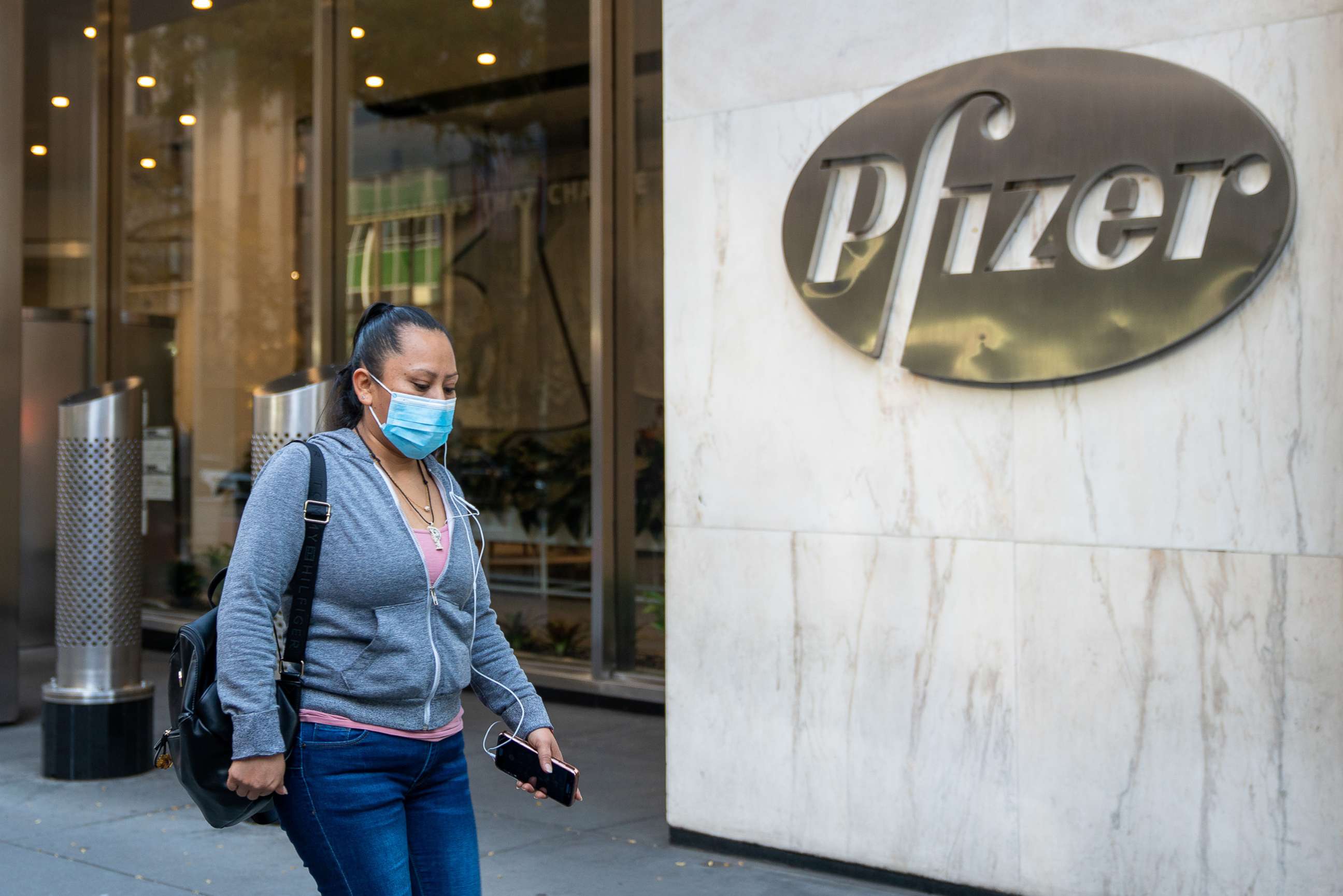 PHOTO: People walk by the Pfizer headquarters, Nov. 9, 2020, in New York. 