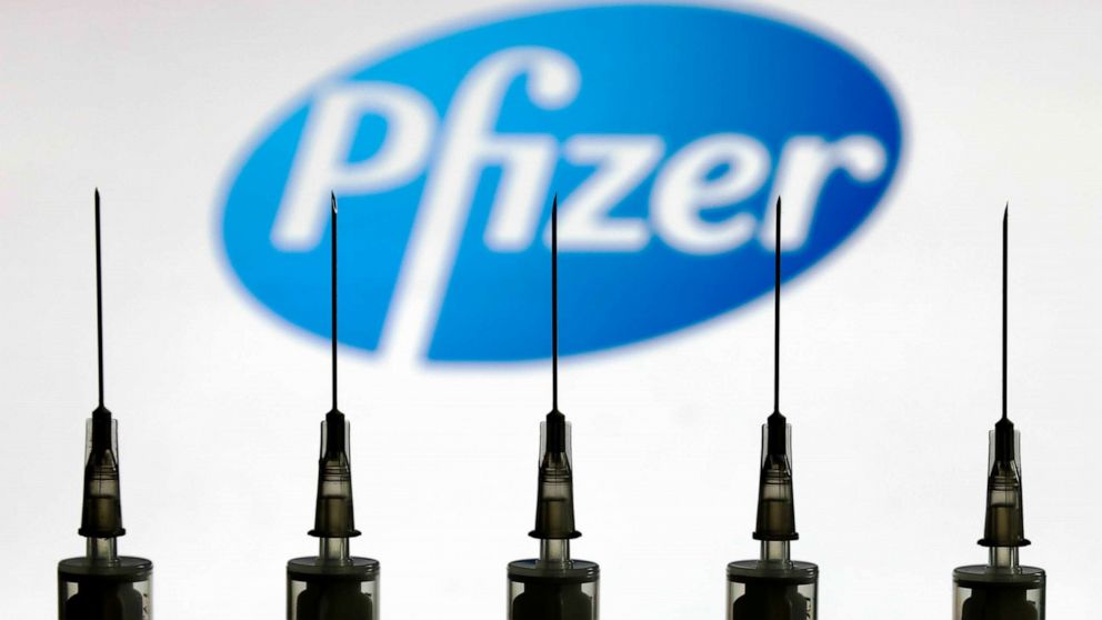 PHOTO: Medical syringes stand in front of the Pfizer company logo, Oct. 12, 2020.