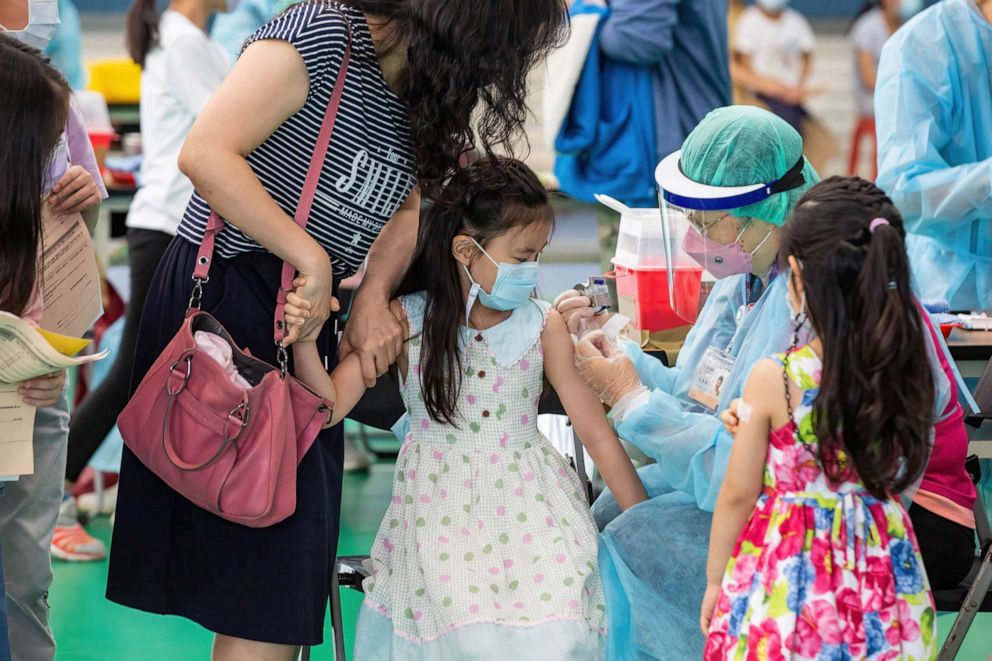 PHOTO: A mother holds her daughter's arm as a healthcare worker administers the child with Pfizer-BNT covid-19 vaccine in Taipei, Taiwan, May 26, 2022.