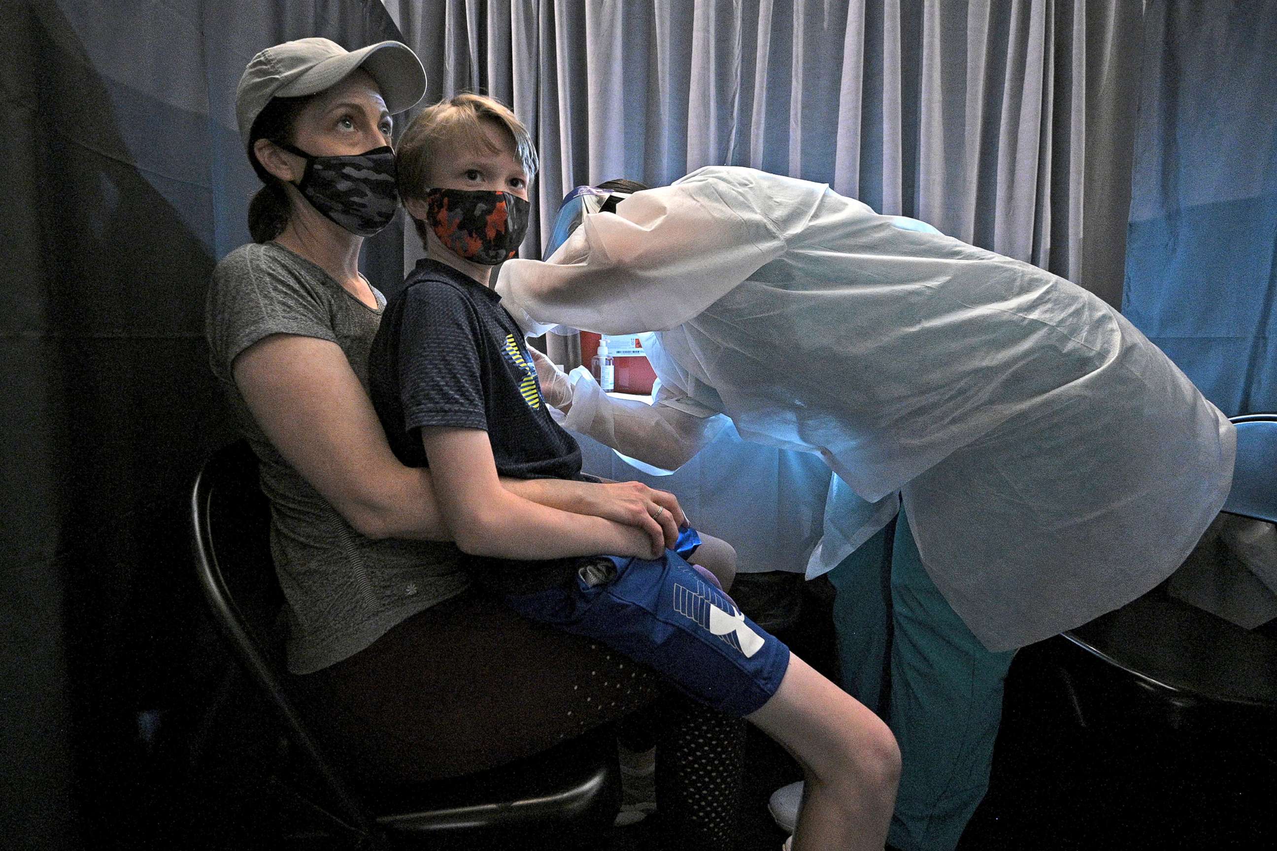 PHOTO: A child sits on his mother's lap as he receives his first dose of the Pfizer COVID-19 vaccine, at a vaccination site set up in the American Museum of Natural History in New York, N.Y., May 18, 2021.