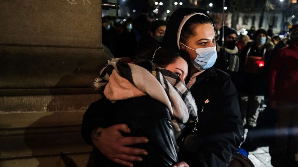 PHOTO: Women hug during a protest in front of the Law and Justice party office, Jan 26, 2022, in Krakow, Poland.