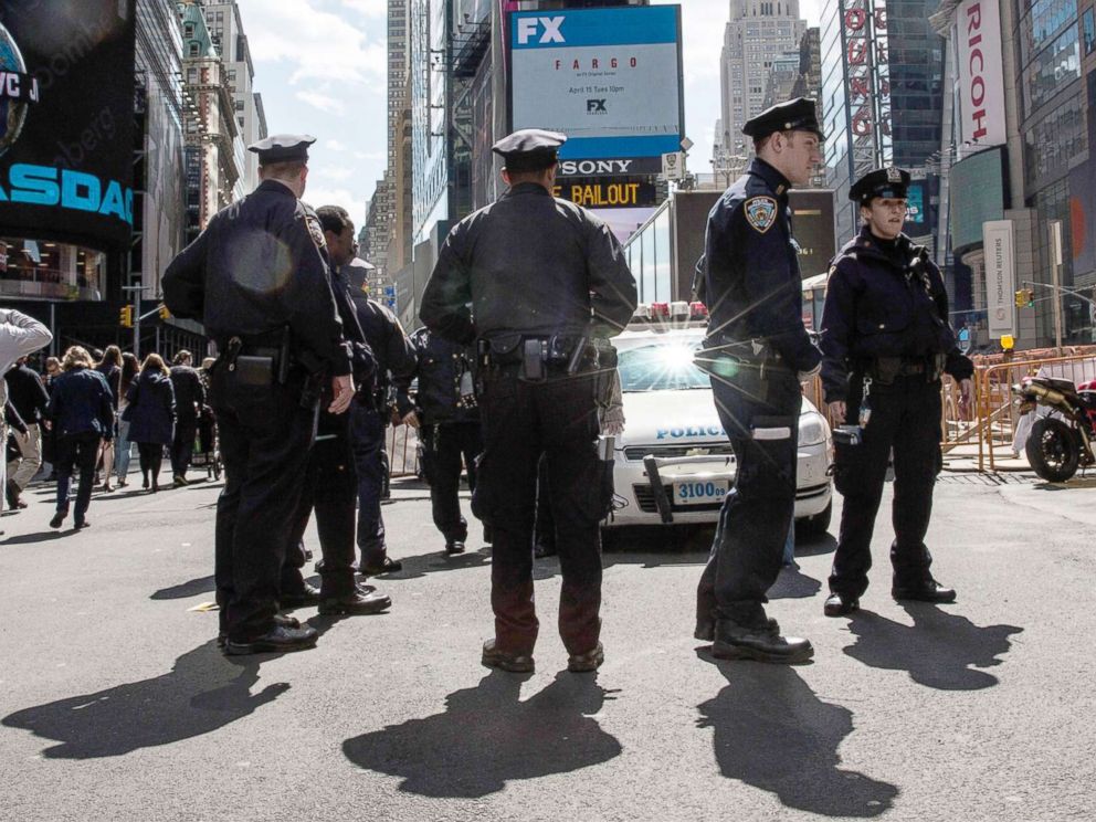 PHOTO: Police officers hold a meeting on the sidewalk while patrolling Times Square, April 9, 2014, in New York City.