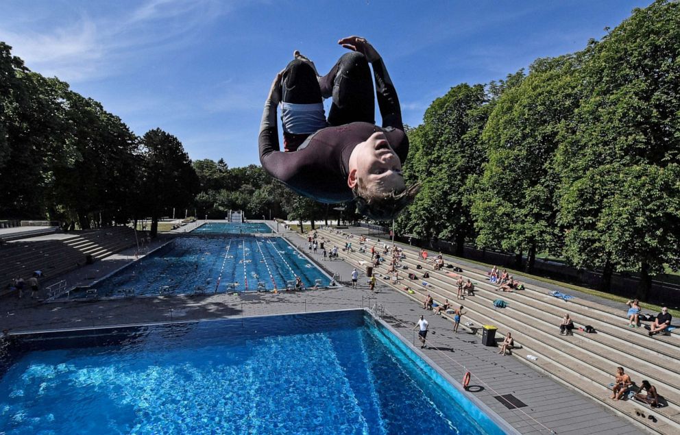 PHOTO: A swimmer jumps into the water during the opening day of the public open air pool in Cologne, Germany, on a warm and sunny Thursday, May 21, 2020.