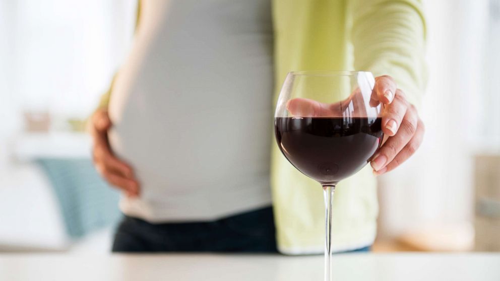 PHOTO: A pregnant woman reaches for a glass of wine.