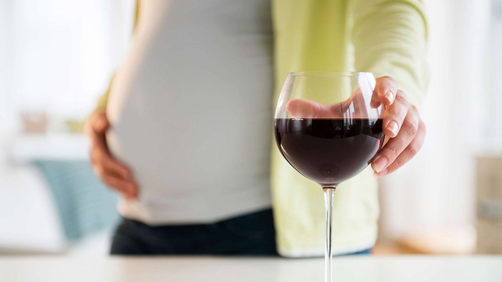 PHOTO: A pregnant woman reaches for a glass of wine.