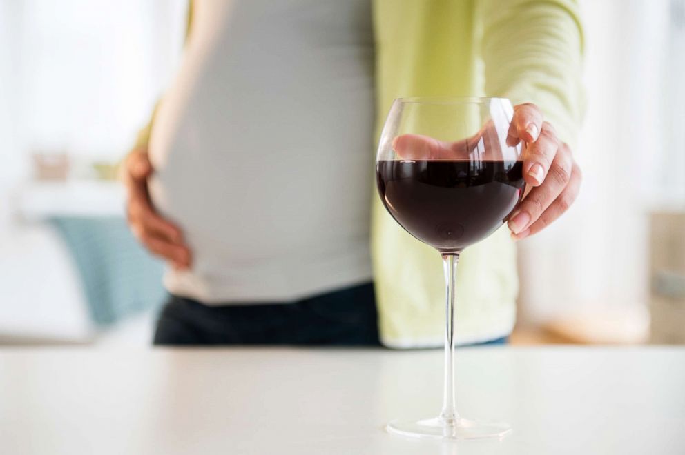 PHOTO: A pregnant woman reaches for a glass of wine.