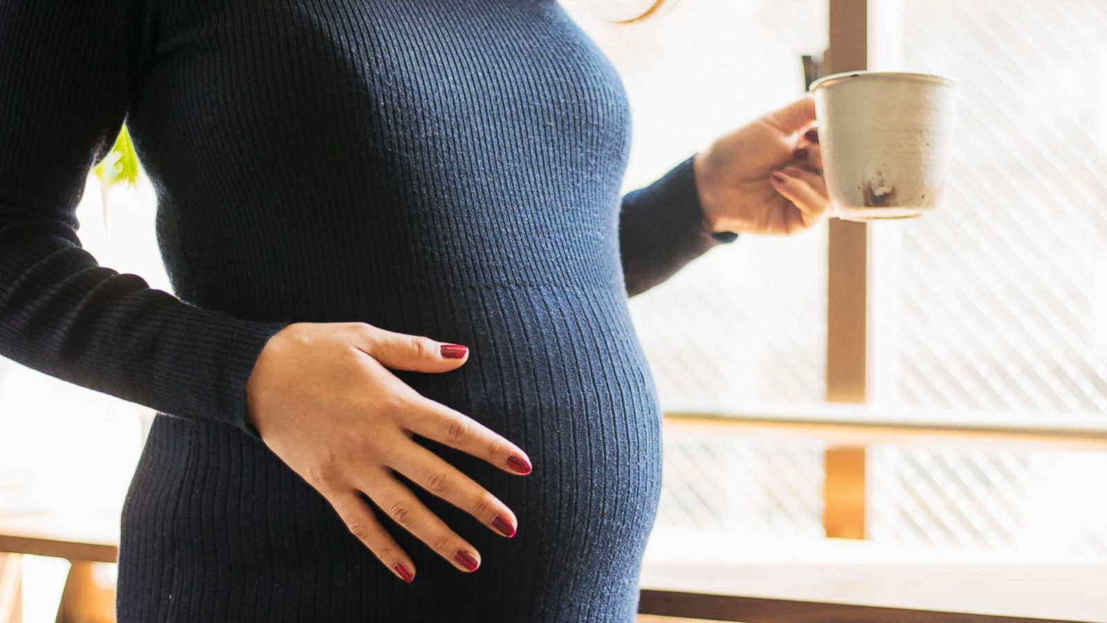 PHOTO: In this undated stock photo, a pregnant woman stands by a window.